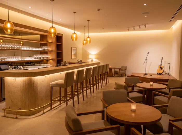 An evening lounge bar with a curved bar, stools, armchairs and a small stage with a microphone and a guitar